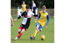 Clevedon Town's Freddie King challenged by former Seasider Callum Gould.