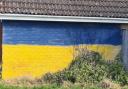 A wall previously marred with graffiti has been replaced with the Ukrainian flag.