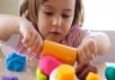 Little girl creating toys from playdough