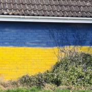 A wall previously marred with graffiti has been replaced with the Ukrainian flag.