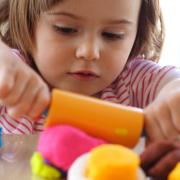 Little girl creating toys from playdough