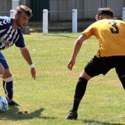 Clevedon Town's Ethan Feltham tries to find a way past Falmouth's Kirk Davies
