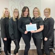Staff holding a £250 cheque at Tonic Hair and Beauty salon