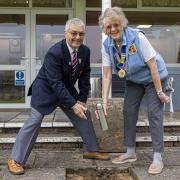 Nailsea Bowls Club Chairman David Hole and Ladies President Patricia Billington placing the time capsule into the ground alongside the newly prepared green.