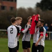 Portishead Town hold aloft a shirt with number five, the number Ollie Hatfield wore during his time with Posset after Ethan Feltham's first goal against Cribbs Reserves,